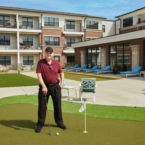 The Grand | Senior man practicing his putting skills on the putting green