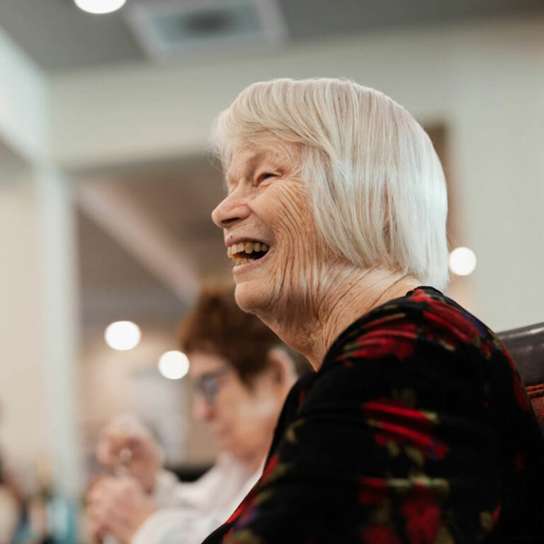 The Grand Senior Living | Senior woman laughing at open house