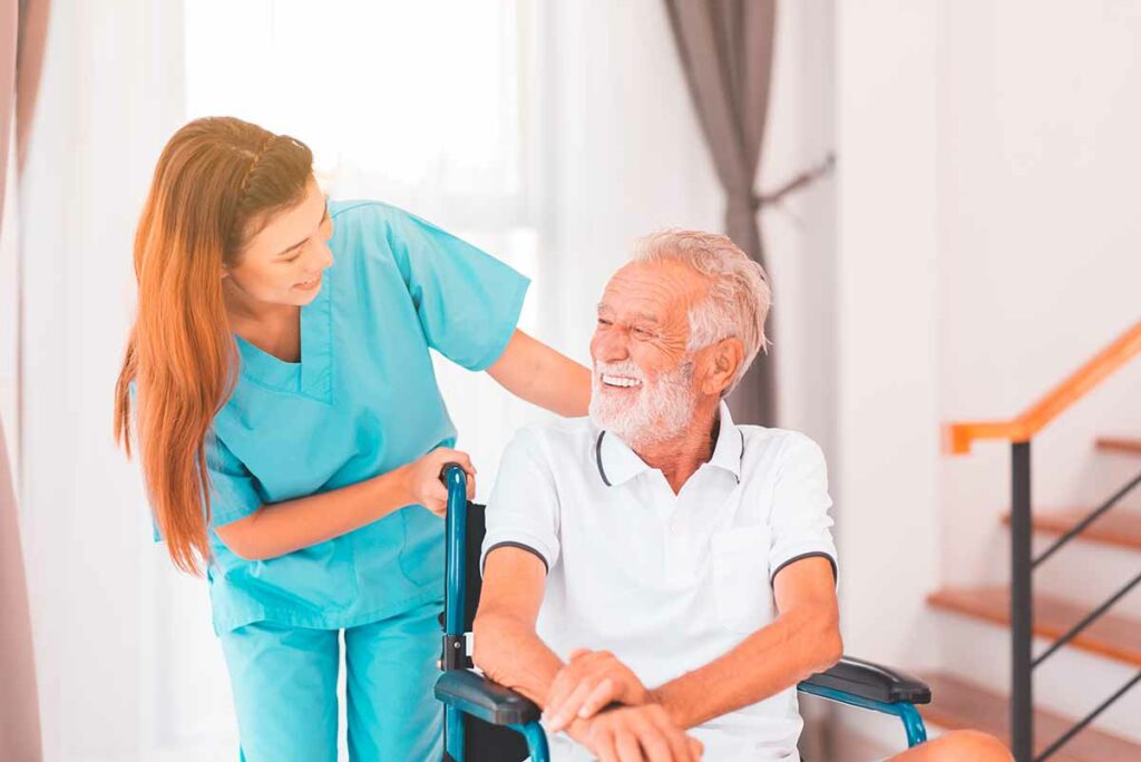 Nurse taking care to elderly man sitting on wheelchair