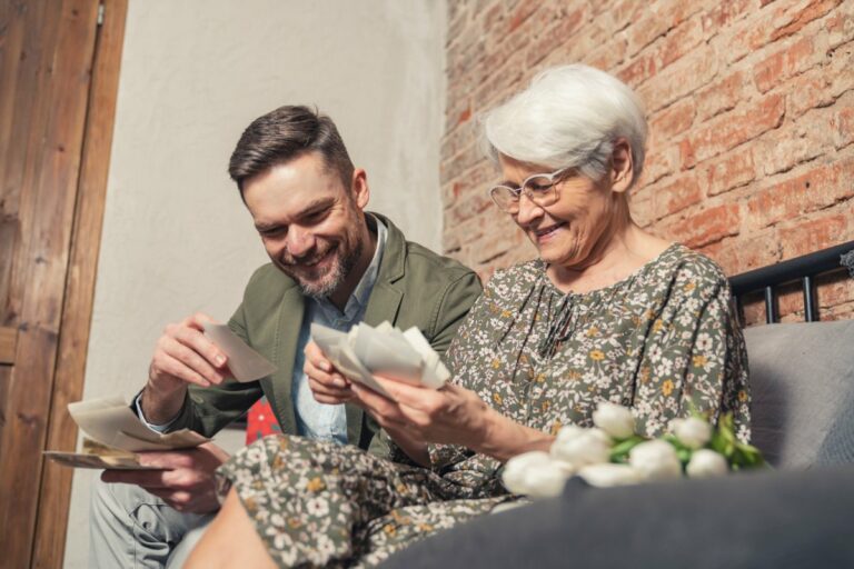 The Grand | Senior woman smiling and looking through photos with younger man