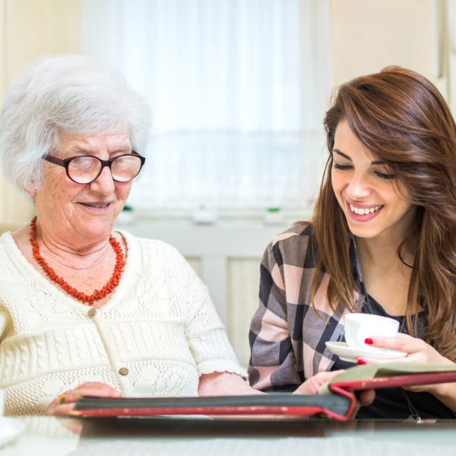 Civitas Senior Living | Senior woman looking a photos with her caregiver
