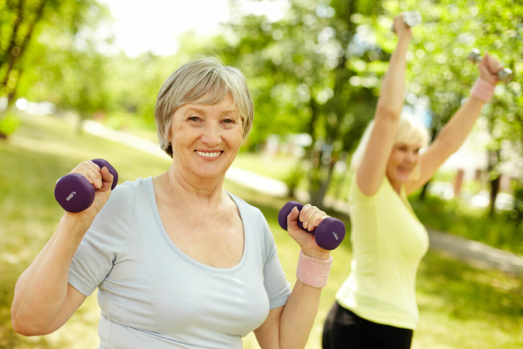 The Grandview of Chisholm Trail | Active senior woman lifting small weights outdoors