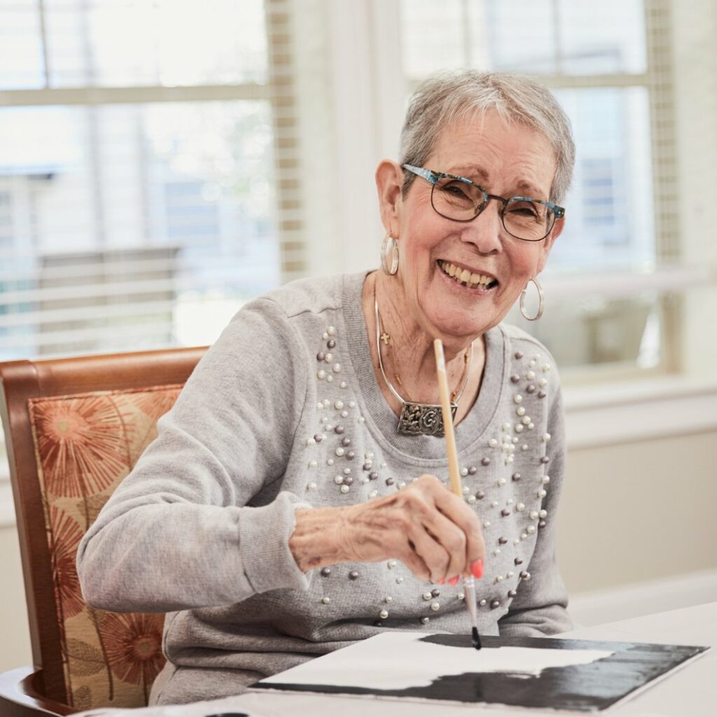 The Grandview of Chisholm Trail | Senior woman smiling while painting