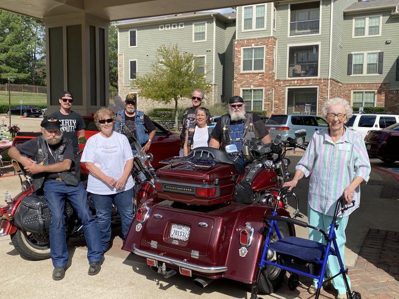 The Hamptons of Tyler | Senior resident, Barbara, posing with motorcyclists and their motorcycles