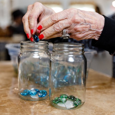 The Hamptons | Senior putting glass stones in jars