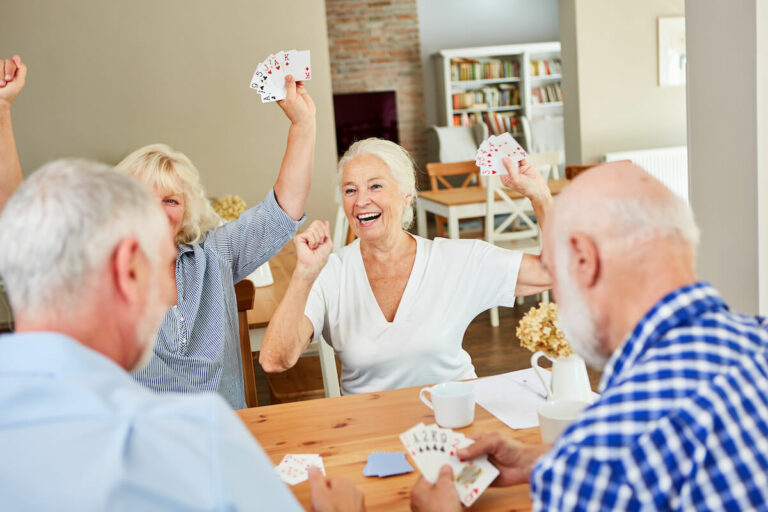 The Hamptons of Tyler | A group of seniors playing a card game