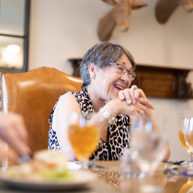 Civitas Senior Living | Senior living community resident laughing at dinner