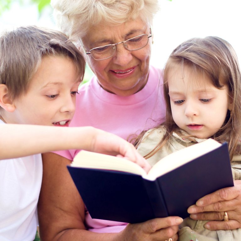 Valley View Senior Living | Senior reading with two younger kids