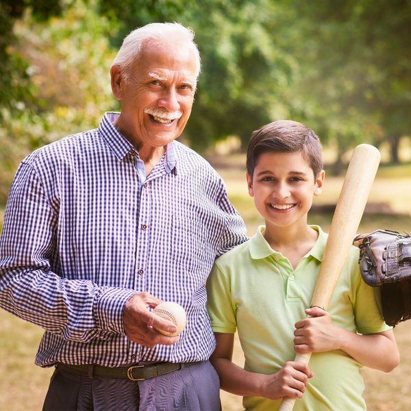 Valley View Senior Living | Senior man holding a baseball with kid holding a bat