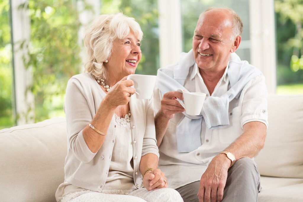 Valley View | Senior couple smiling and drinking coffee on the couch