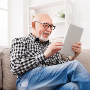 Civitas Senior Living | Senior man using tablet on couch