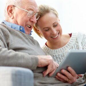 Civitas Senior Living | Senior man browsing news and resources on his tablet with daughter