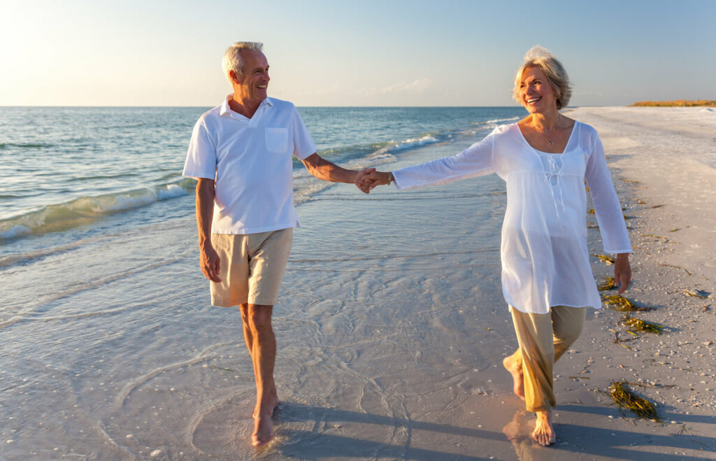 Civitas Senior Living | Happy senior couple walking on a Florida beach