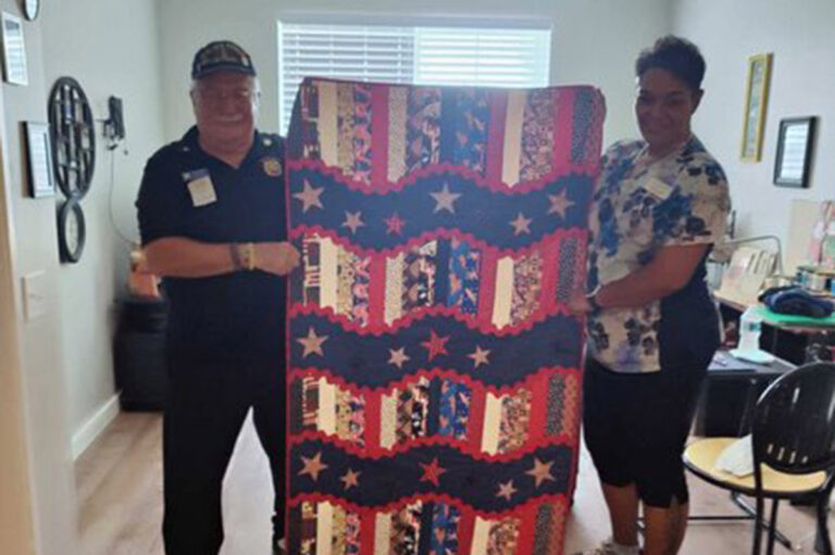 The Azure of Palm Coast | Senior resident showing off his red white and blue quilt
