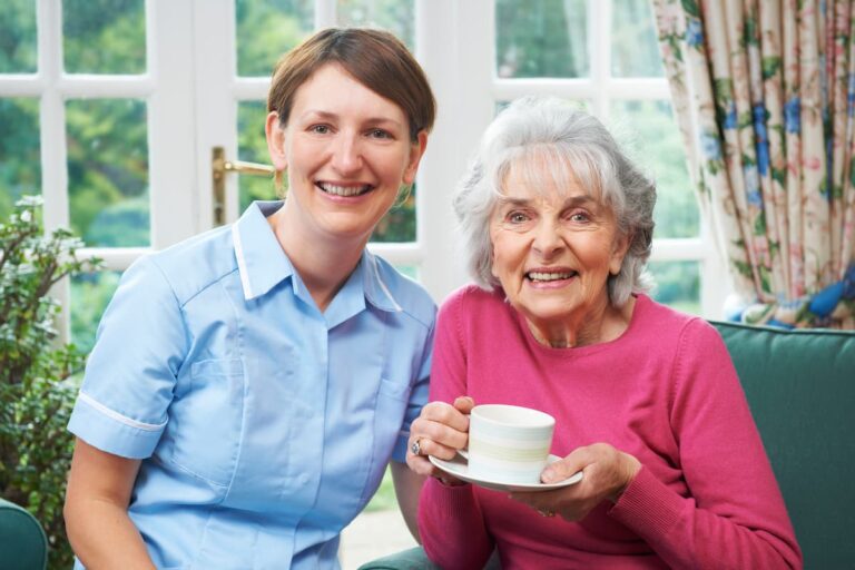 The Grandview of Chisholm Trail | Smiling senior woman drinking tea with caregiver