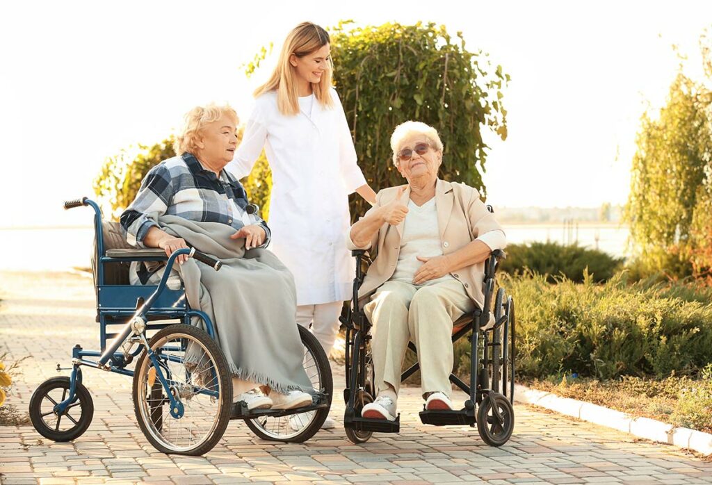 StoneCreek of Flying Horse | Seniors outdoors in their wheelchairs with their caregiver