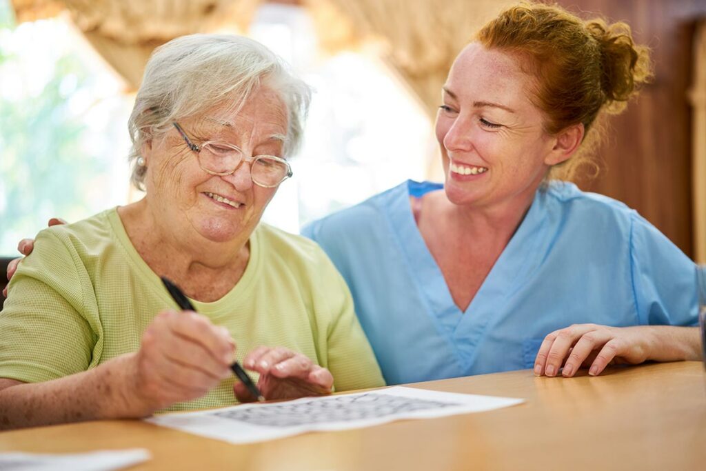 Harvest of Aledo | Senior woman with caregiver doing crossword puzzle