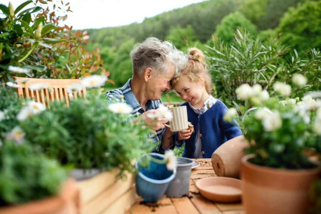 StoneCreek of Flying Horse | Senior woman and her granddaughter sitting by the flowers