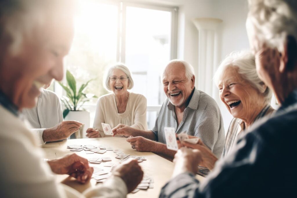 StoneCreek of Littleton | Happy group of seniors playing cards together at table