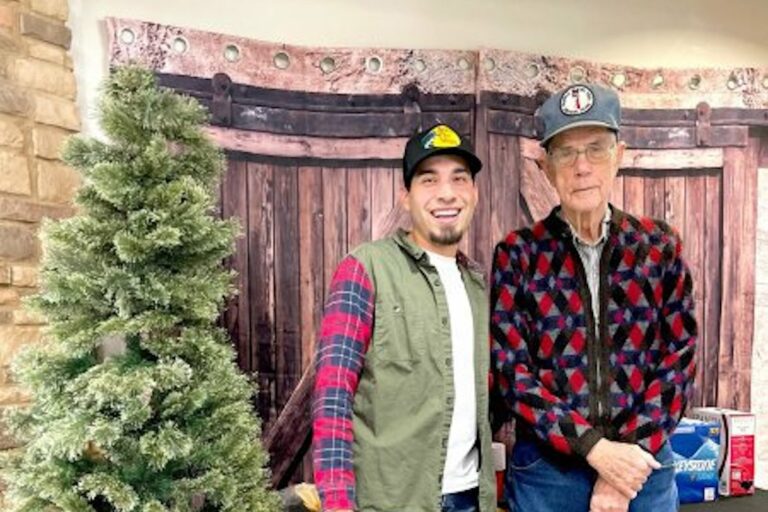 The Avenues at Fort Bend | Seniors and community staff member standing next to a Christmas tree