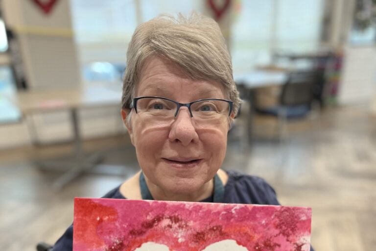 Legacy Oaks of Azle | Vicki holding up her heart painting