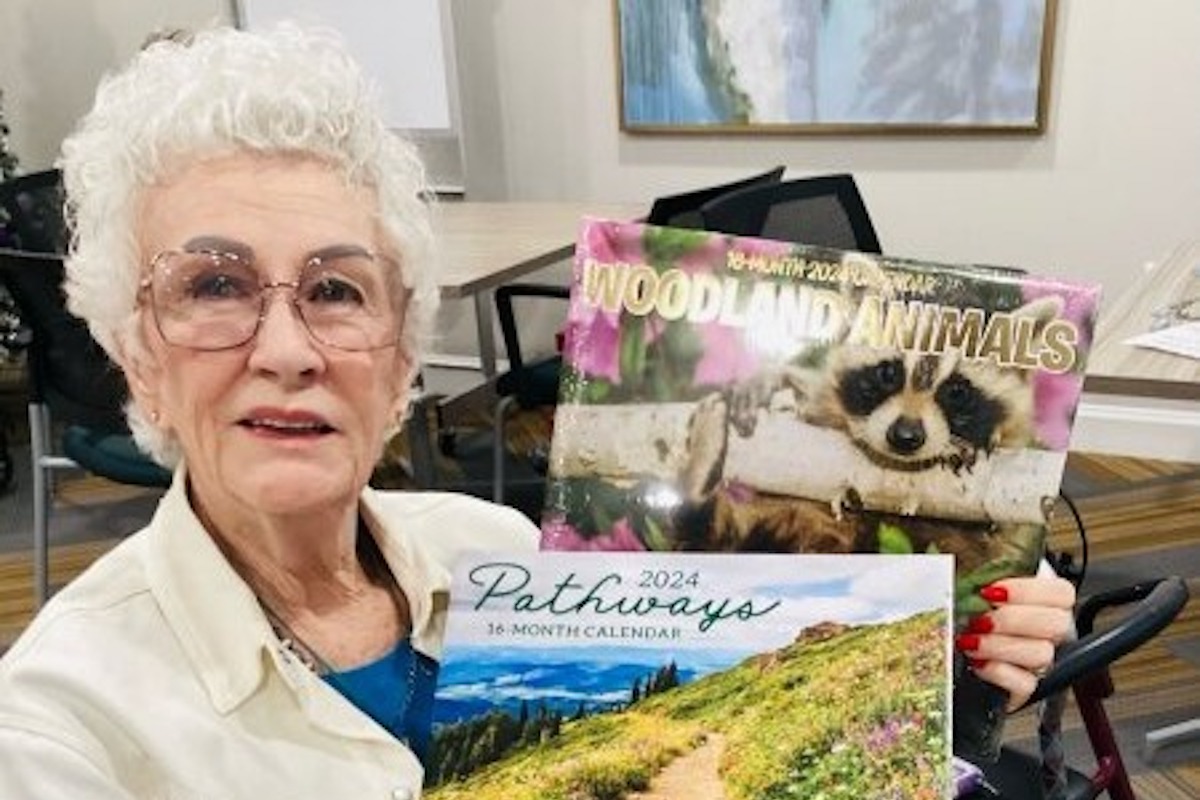 Stonecreek of Copperfield | Senior holding up Houston themed calendars