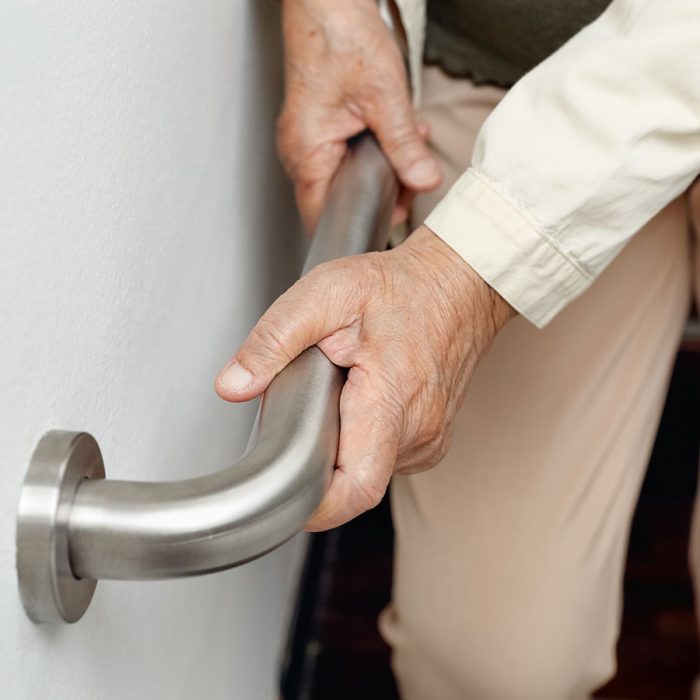Civitas Senior Living | Senior woman holding on to handrail