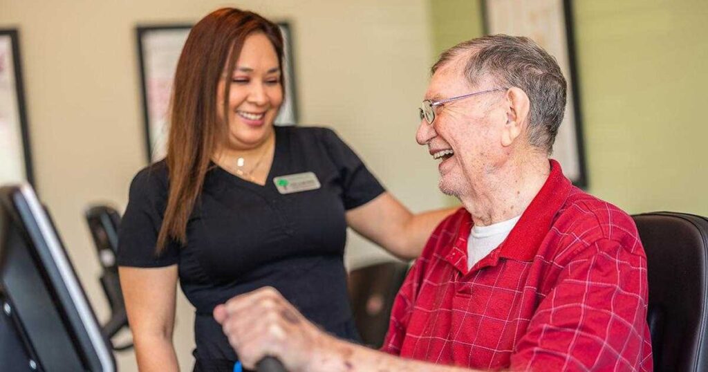Civitas Senior Living | Senior exercising on machine with the guidance of a staff member