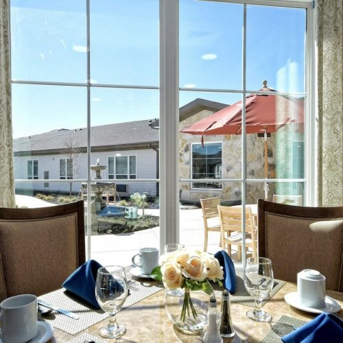 Alexis Pointe of Wimberley | Dining room table view looking out at the courtyard