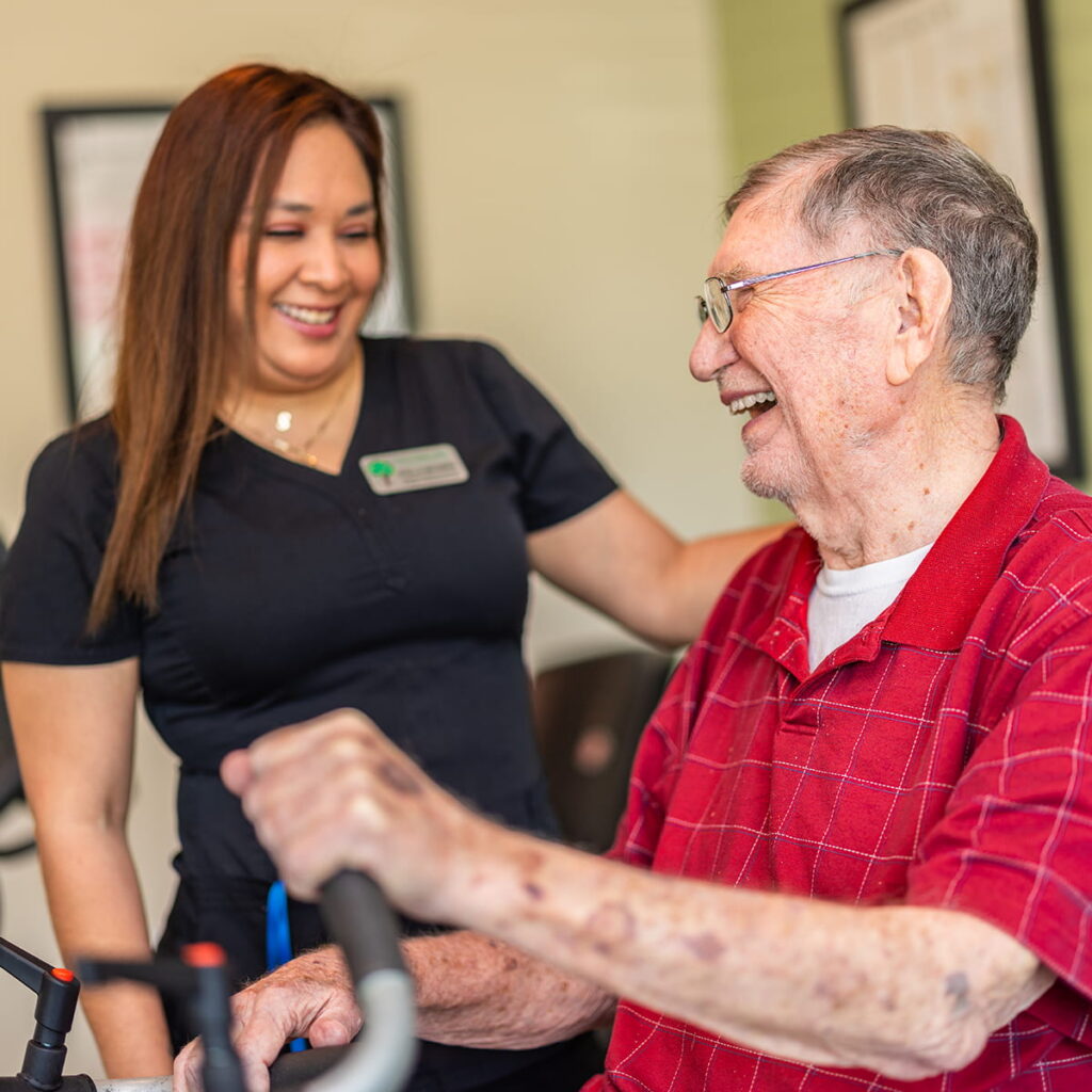 Civitas | Team member assisting resident on exercise bike