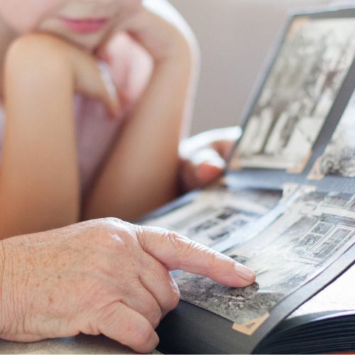 Stone Creek of Copperfield | Senior pointing at photo album with granddaughter