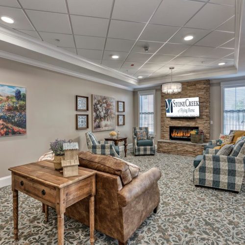 StoneCreek of Flying Horse | Memory care family room with fireplace