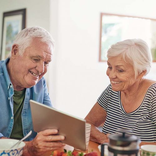 StoneCreek of Flying Horse | Colorado memory care facilities | Senior couple looking at their tablet and smiling