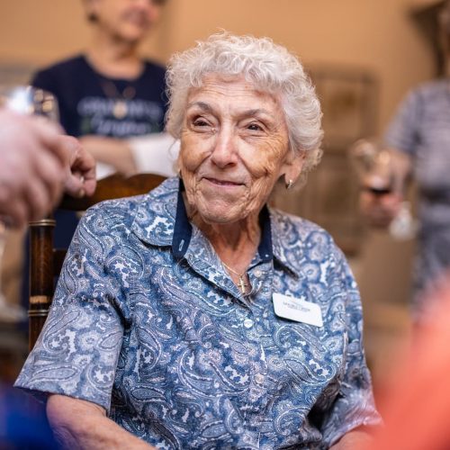 Double Creek | Smiling senior woman surrounded by friends