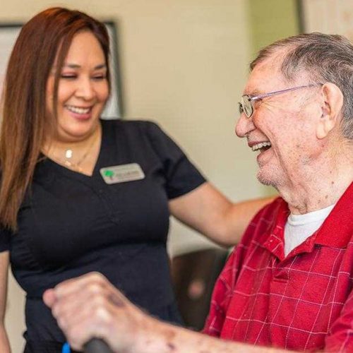 Civitas Senior Living | Senior exercising on machine with the guidance of a staff member