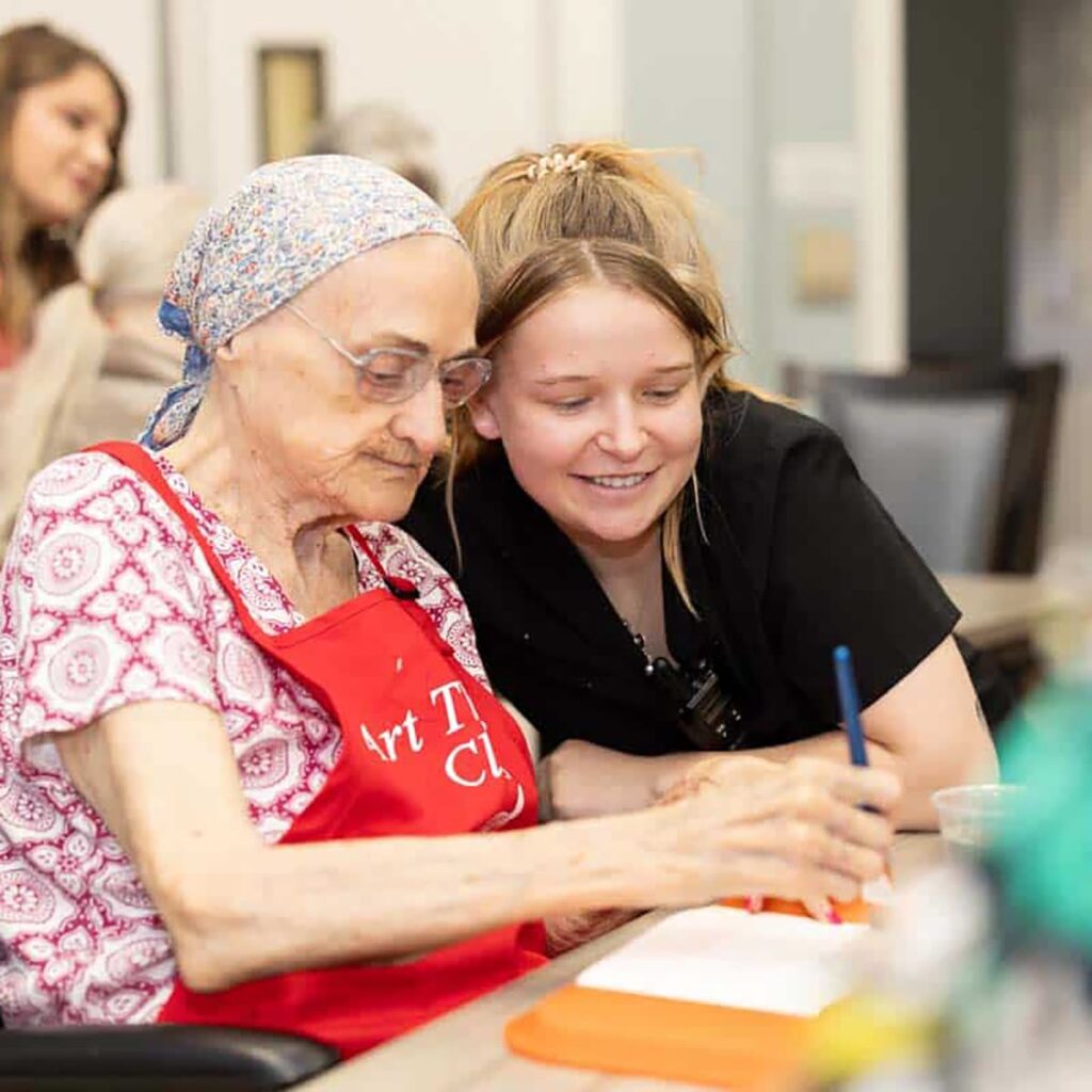 The Avenues of Fort Bend | Senior woman painting with caregiver